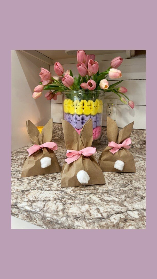 Brown paper bunny gift bags with pink ribbons and white pom-pom tails.