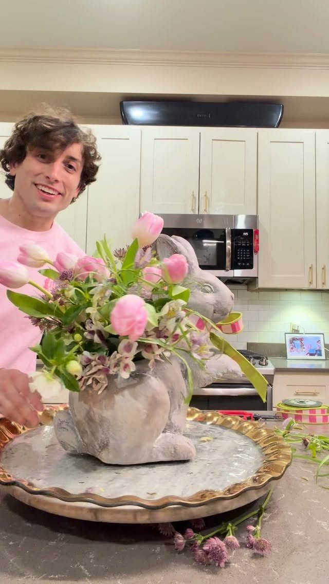 Bunny shaped planter filled with pink tulips and spring flowers on a tray.