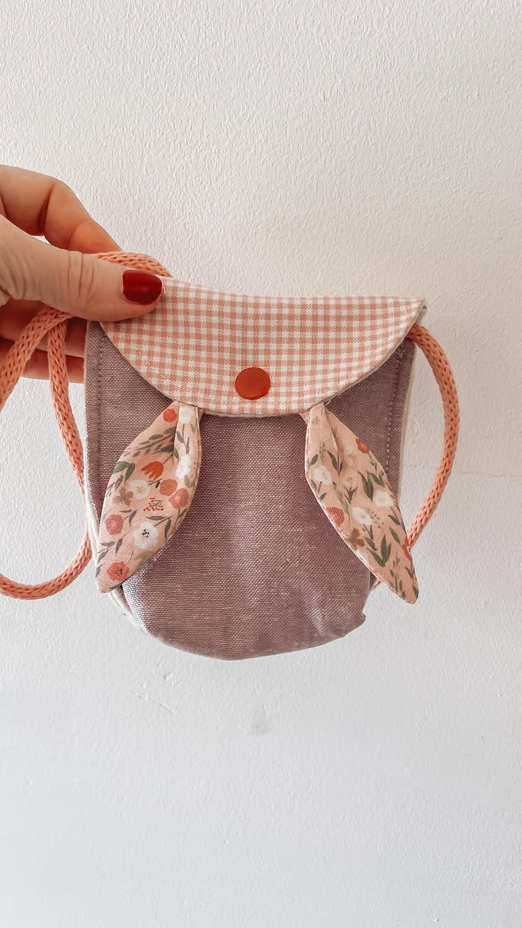 Handmade bunny-shaped fabric pouch with pink gingham flap and floral ears.