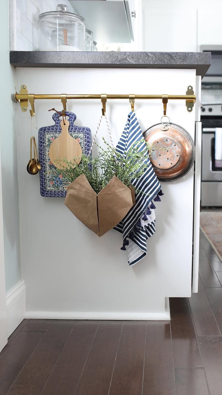 Brown paper origami basket with green plants hanging on a gold kitchen rail