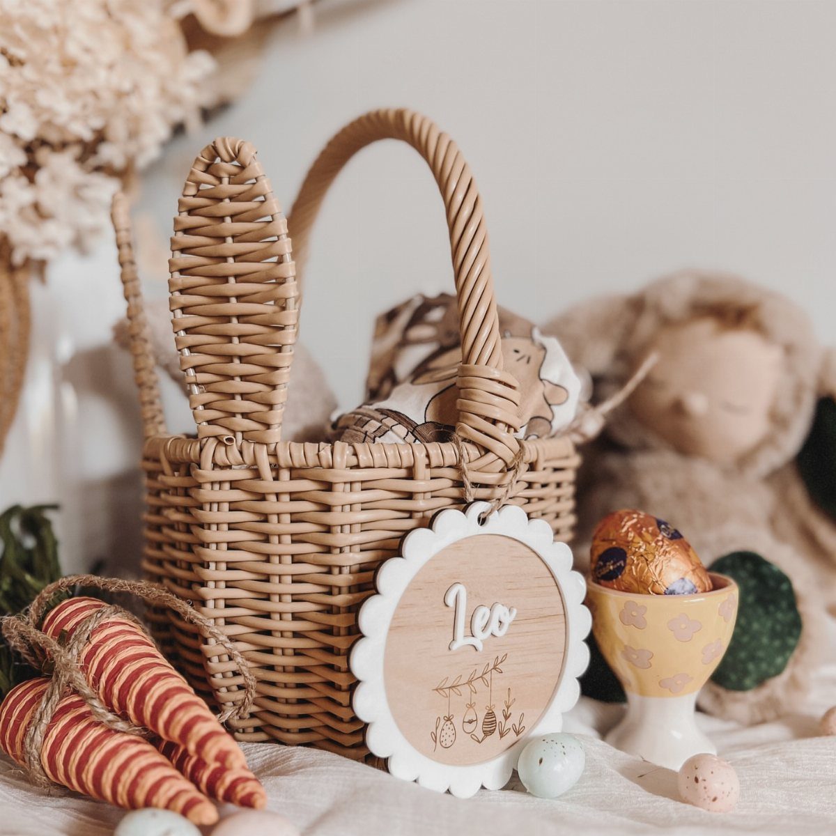Personalized wooden basket tag with name Leo attached to a wicker bunny basket.