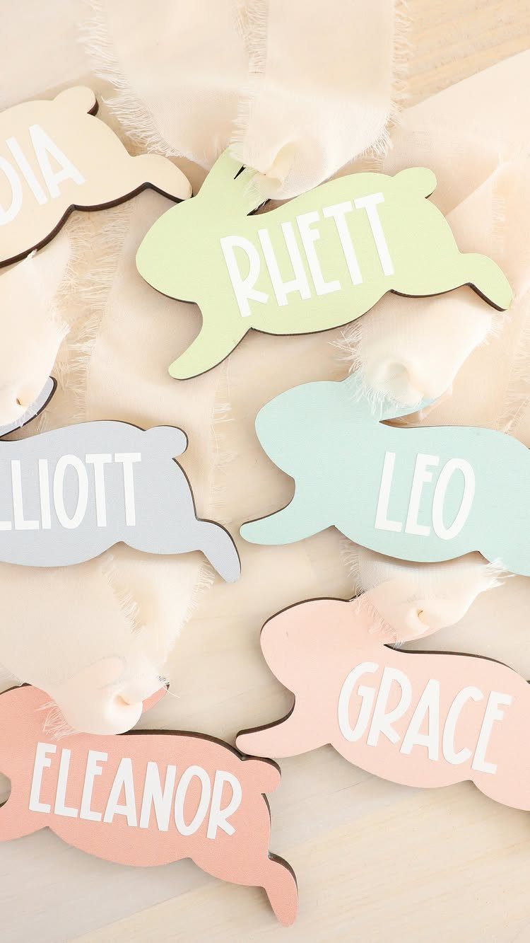Pastel bunny-shaped wooden name tags tied with white ribbons for Easter gifts.