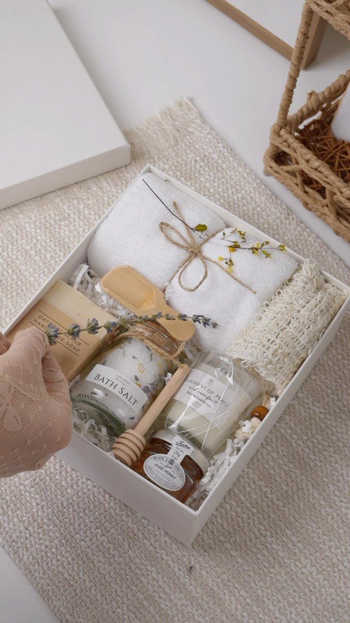 8 Small Gift for Mom Ideas, From Bath Soaks to Baskets 1 Spa gift box with bath salt, candle, honey, and rolled white towel.