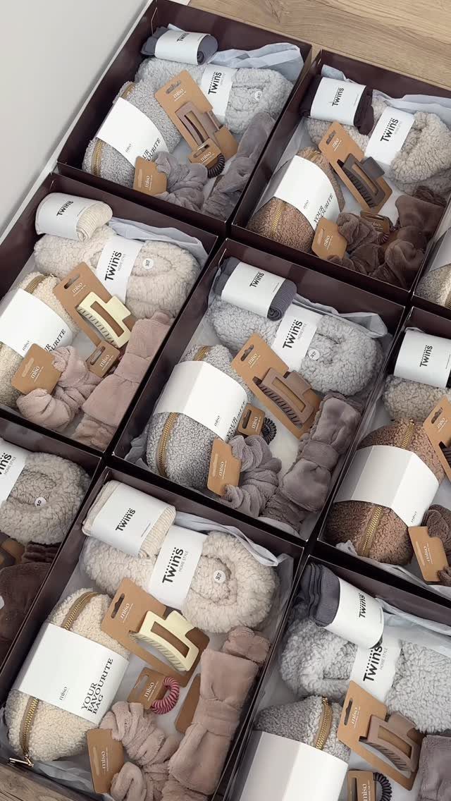 8 Small Gift for Mom Ideas, From Bath Soaks to Baskets 6 Gift boxes containing fluffy slippers, soft socks, and headbands in neutral colors.