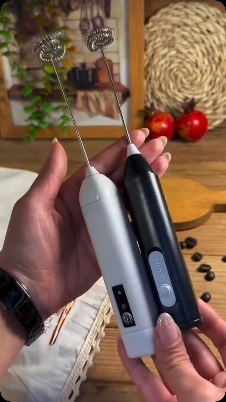 14 Small Unisex Gifts for Friends, Coworkers and Family 10 Two handheld electric milk frothers in white and black held by hands.