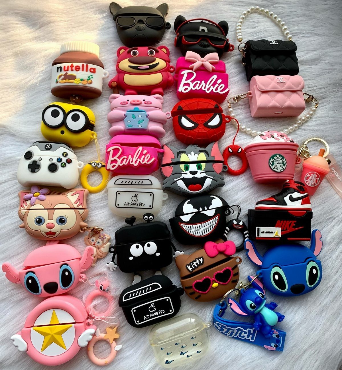14 Small Unisex Gifts for Friends, Coworkers and Family 9 Assorted colorful character-themed AirPod cases arranged on a white fluffy background.