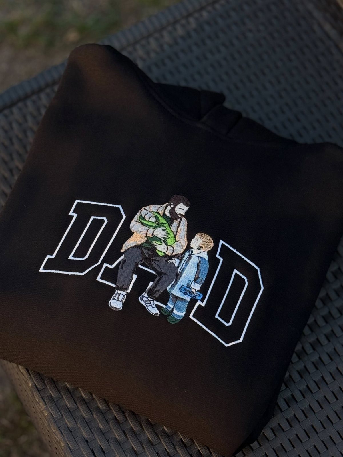 11 Step Father Gifts: From a Pocket Knife to a Photo Plaque 7 Black hoodie with white DAD text and embroidered father and son hugging.