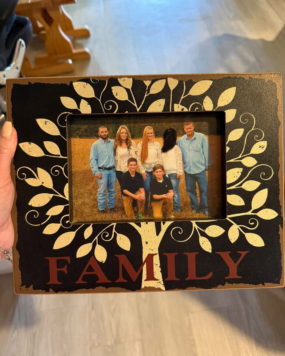 11 Step Father Gifts: From a Pocket Knife to a Photo Plaque 6 Wooden family picture frame with a white tree design and a family photo.