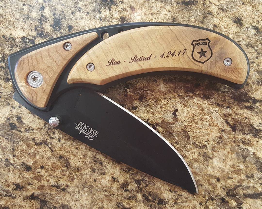 11 Step Father Gifts: From a Pocket Knife to a Photo Plaque 1 Engraved pocket knife with wooden handle and black blade on granite countertop