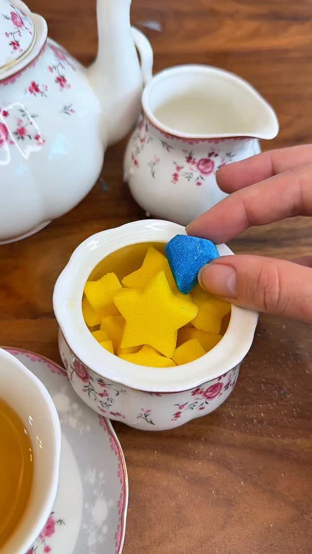 Tea Bag Gift Ideas to Make or Buy: 11 Sweet Picks 7 Hand picking a blue heart tea bag from a bowl of yellow stars.