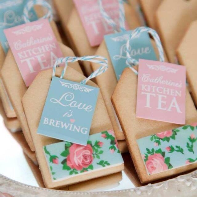 Tea Bag Gift Ideas to Make or Buy: 11 Sweet Picks 1 Tea bag-shaped cookies with floral decorations and small paper tags on a platter.