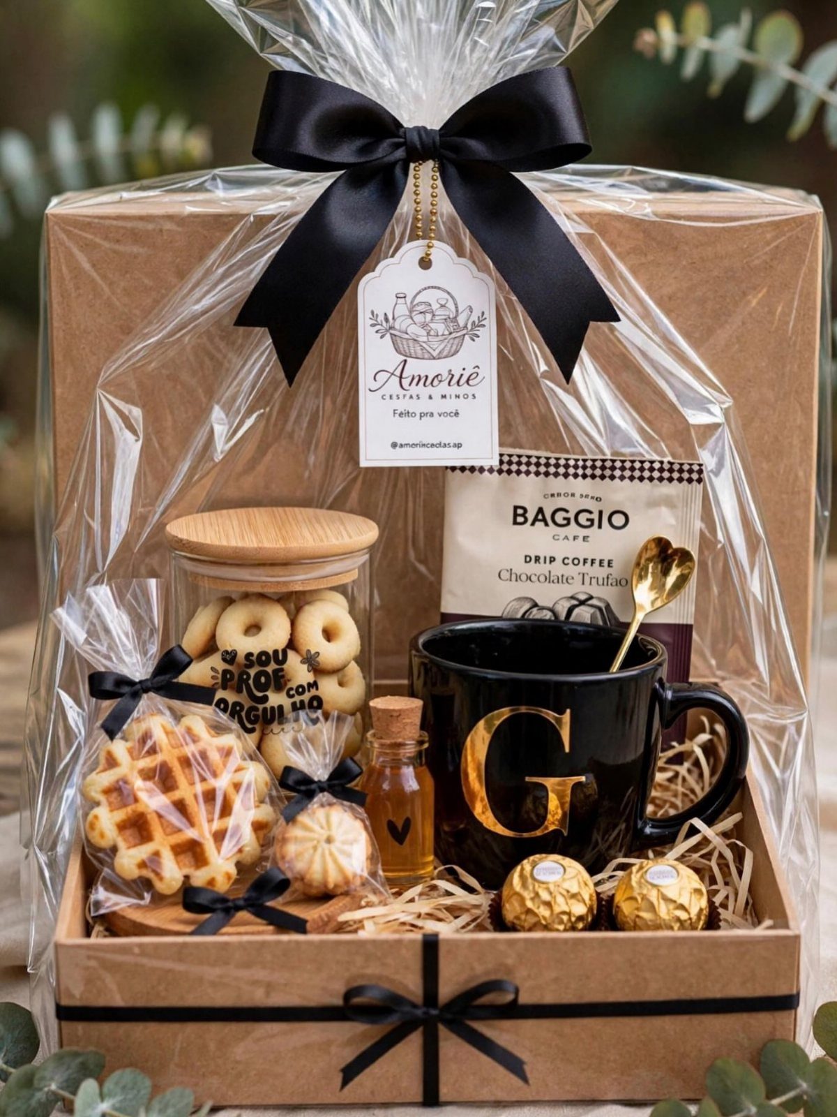 Gift basket with black mug, drip coffee, cookies, and chocolates wrapped in cellophane.