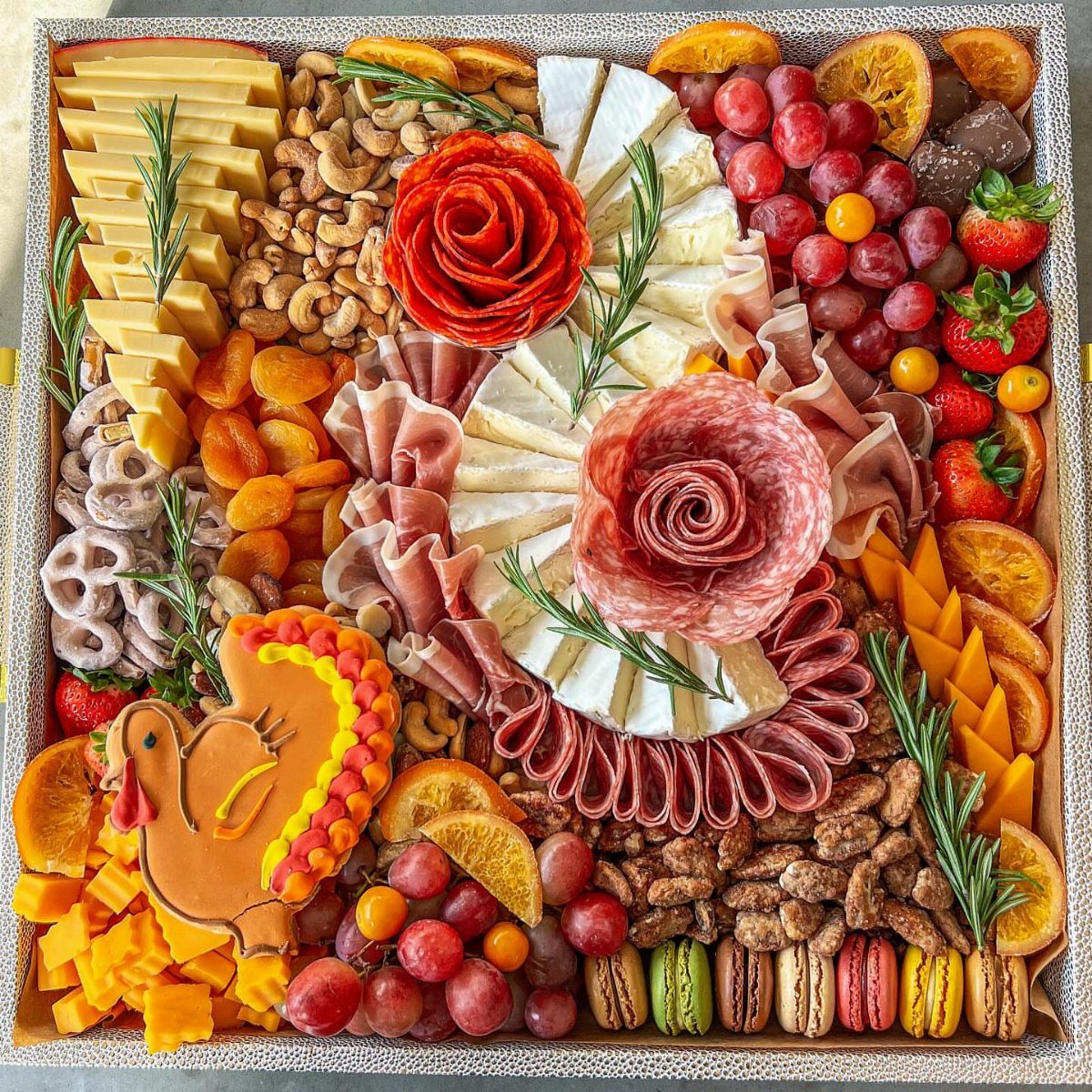 8 Thanksgiving Gift Box Ideas for Hosts and Friends 3 Charcuterie gift box with meats, cheeses, fruits, and a turkey-shaped cheese cutout.