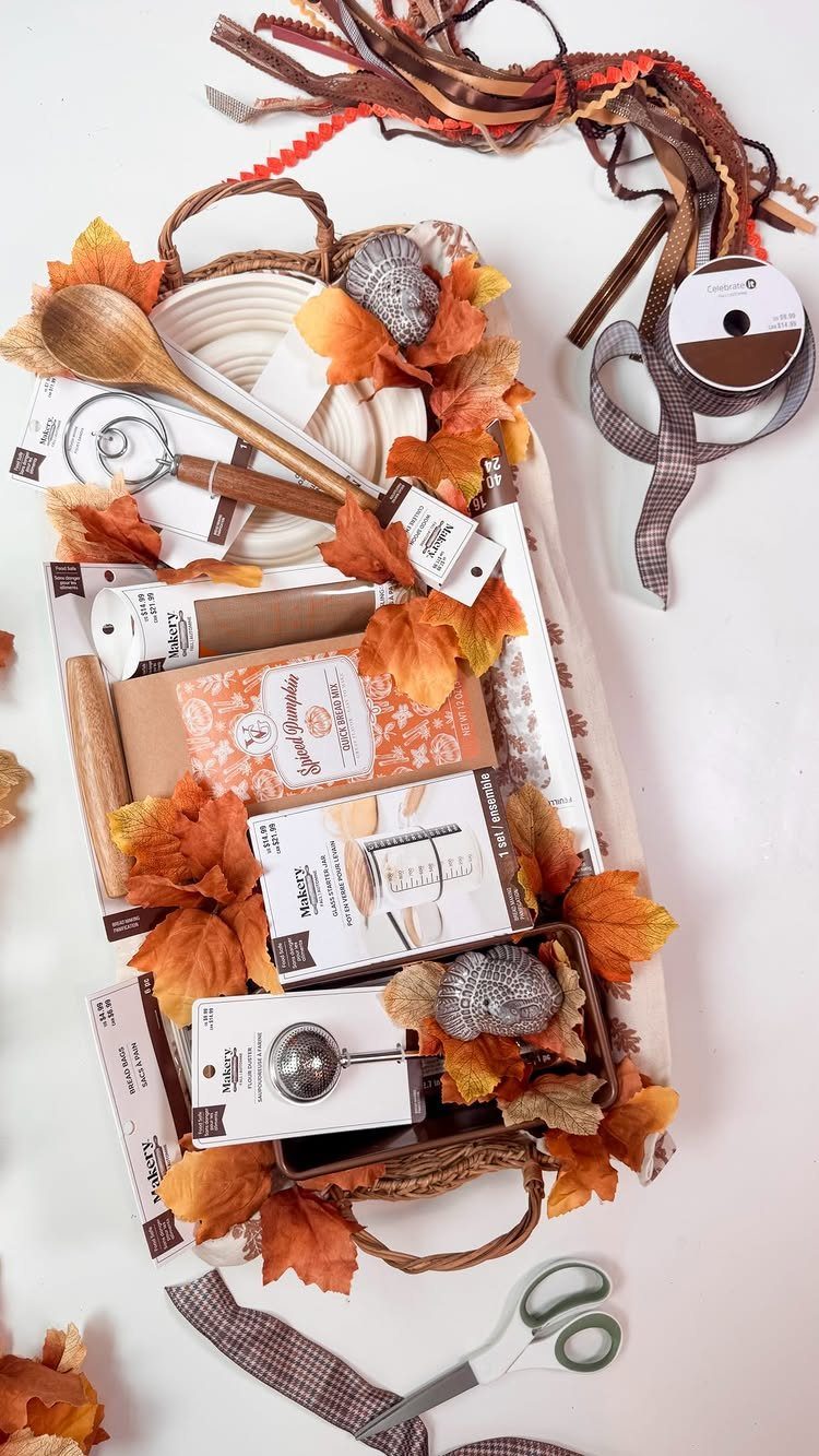 12 Thanksgiving Gifts for Coworkers They'll Actually Use 11 Baking gift basket with autumn leaves, wooden spoon, and cake mix for Thanksgiving.