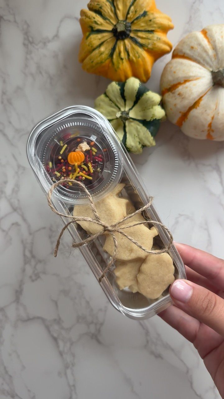 12 Thanksgiving Gifts for Coworkers They'll Actually Use 7 Cookies and sprinkles in a tied plastic container next to decorative pumpkins