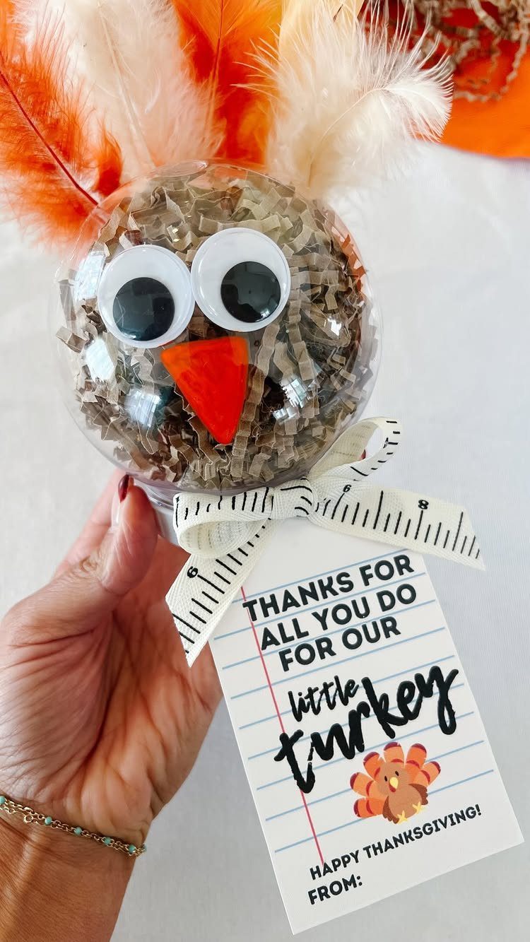 12 Thanksgiving Gifts for Coworkers They'll Actually Use 6 Turkey-themed ornament gift with a Thanksgiving thank you tag held by a hand.