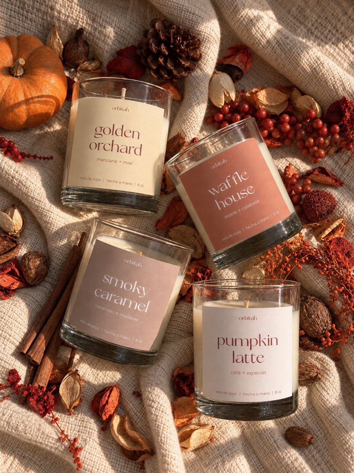 11 Thanksgiving Gifts for Family, From Candles to Cozy Throws 6 Four fall-scented candles arranged with a pumpkin, cinnamon sticks, and autumn botanicals.