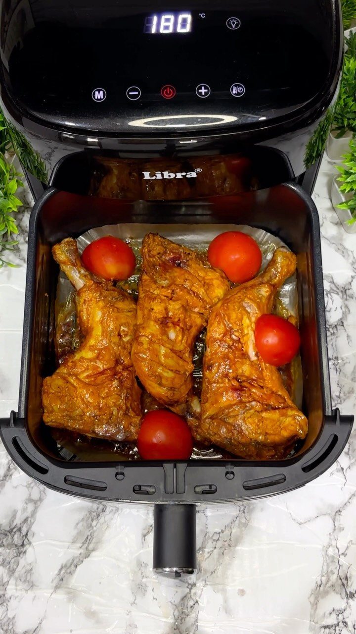 29 Trendy Gift Ideas for Her: The 2026 Gift Guide 3 Black air fryer containing cooked chicken and red tomatoes on marble surface