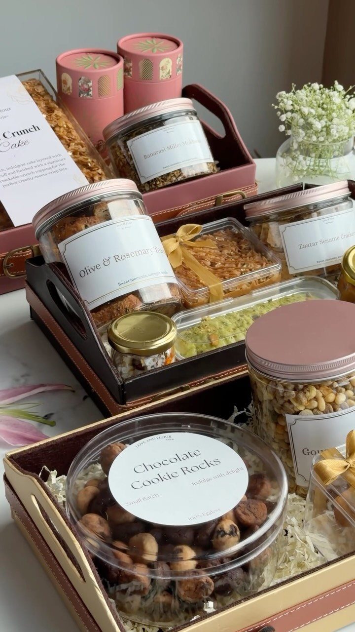 29 Trendy Gift Ideas for Her: The 2026 Gift Guide 27 Gourmet gift hampers filled with assorted snacks, cakes, and jars in elegant trays.
