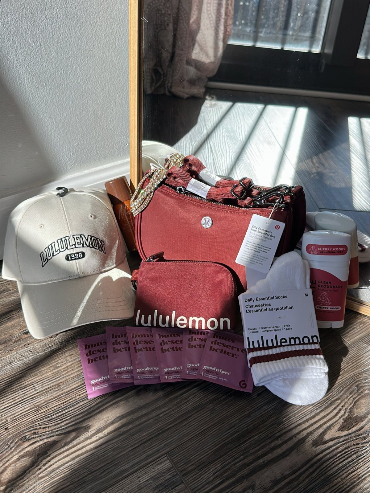 29 Trendy Gift Ideas for Her: The 2026 Gift Guide 15 Lululemon branded white cap, red waist bag, and white socks on wooden floor.