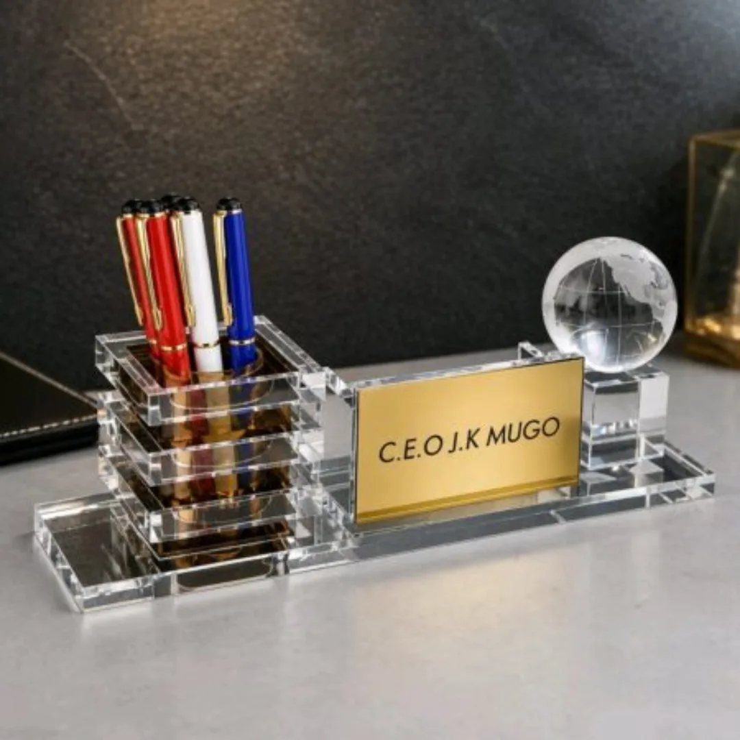 9 Unique Gift for Boss 3 Acrylic desk organizer with colorful pens, gold nameplate, and a crystal globe.