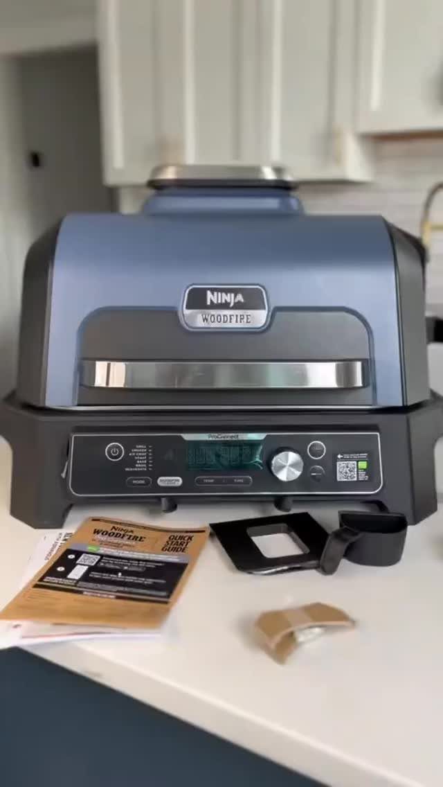 12 Useful Gifts for Dad: Practical Picks He'll Actually Use 3 Ninja Woodfire outdoor grill on a white counter with a user manual.
