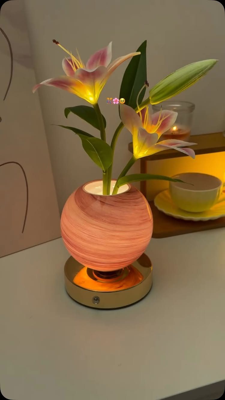 Glowing lily flower lamp in a pink marbled vase on a white table