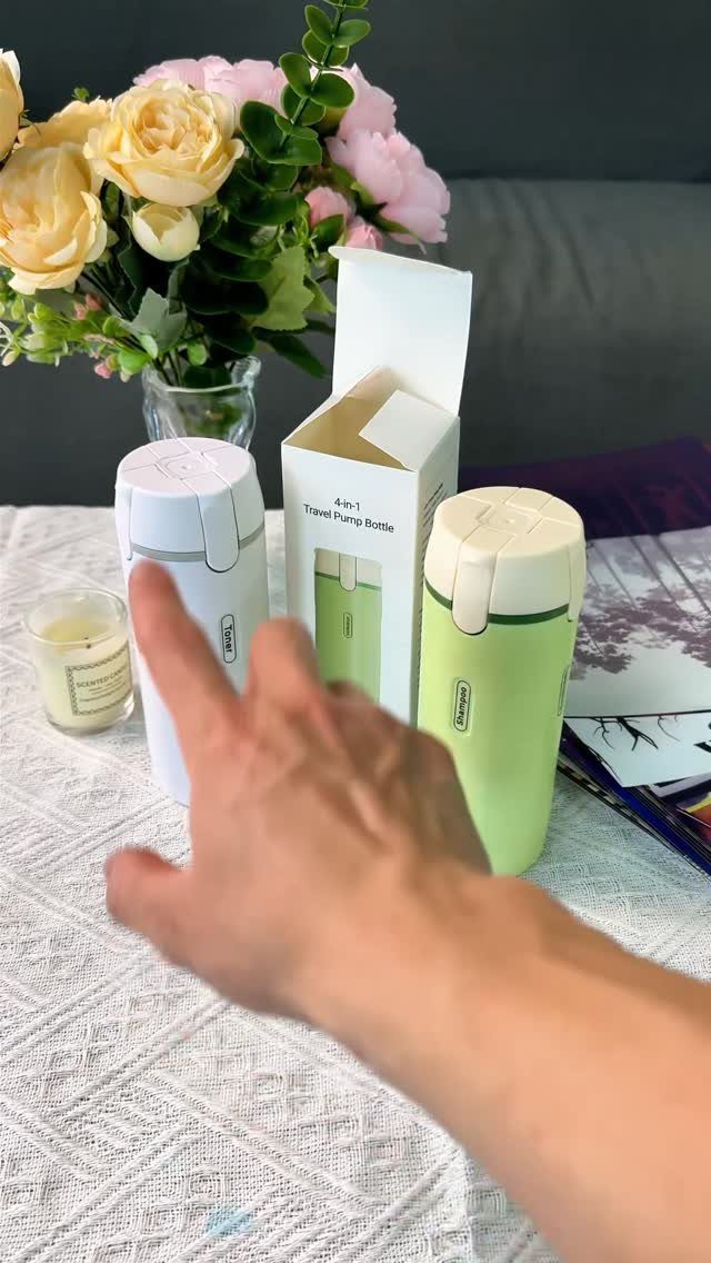 Travel pump bottles in white and green next to a floral bouquet.