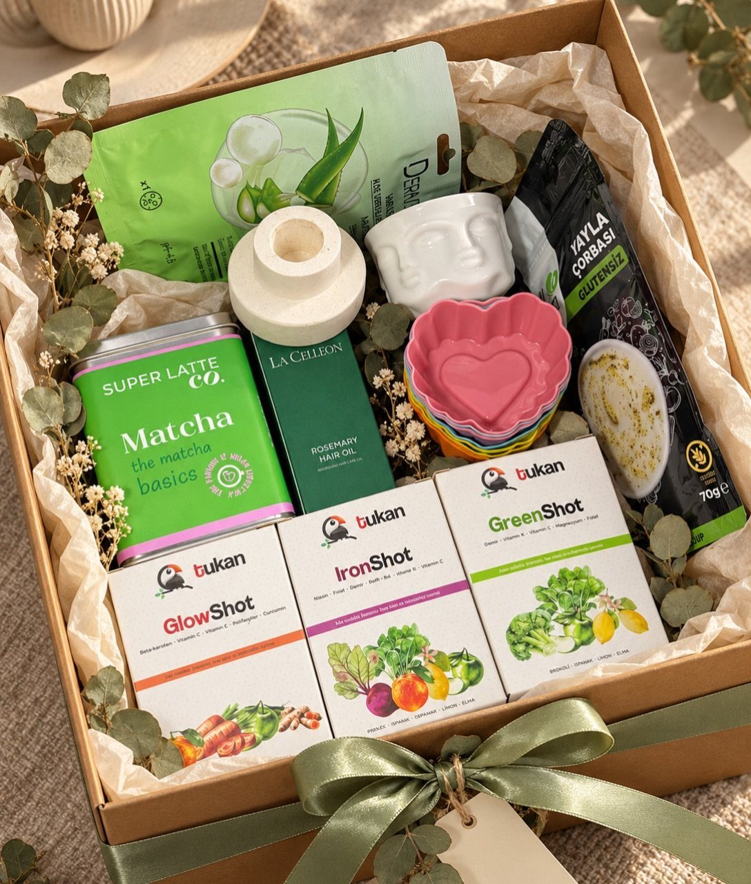Wellness gift box with matcha, health supplements, and self-care items tied with green ribbon.